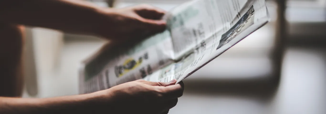 Hands holding a newspaper