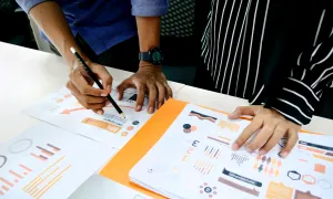 two individuals reviewing a series of charts and graphs