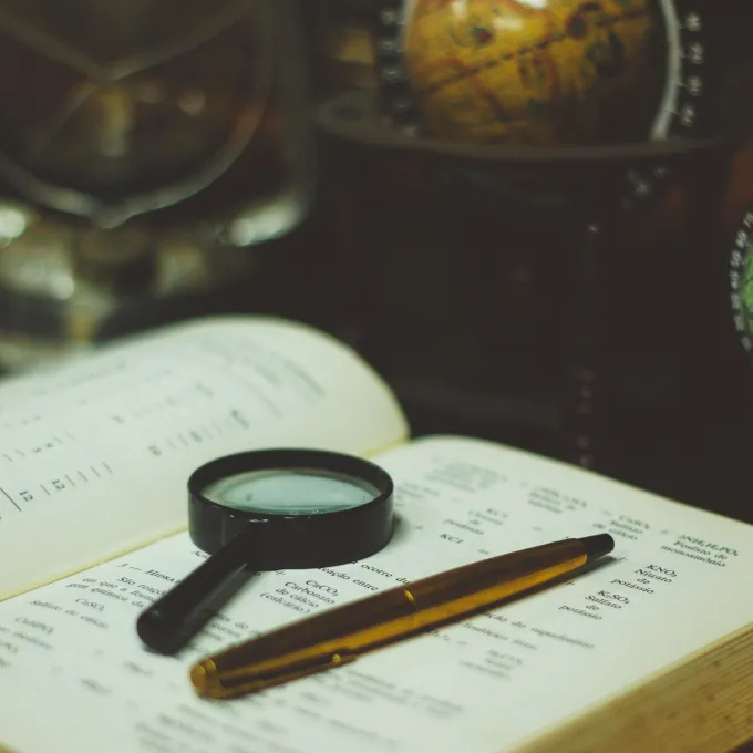 Open book with magnifying glass